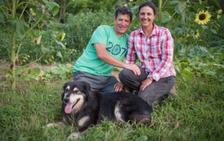 Two people with their dog in front